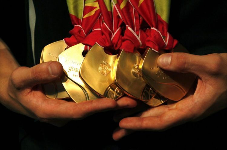 Brazil's swimmer Thiago Pereira holds his Pan-American medals during a media conference in Sao Paulo October 24, 2011. Pereira was crowned king of the Pan-American pool after won seven medals, five gold, one silver and one bronze.  REUTERS/Paulo Whitaker (BRAZIL - Tags: SPORT SWIMMING)