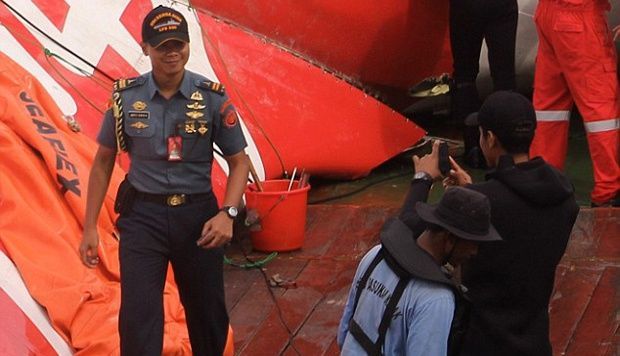 Oknum petugas yang berfoto di depan bangkai pesawat