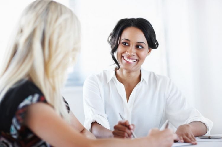 Two stress-free female co-workers look over the plans