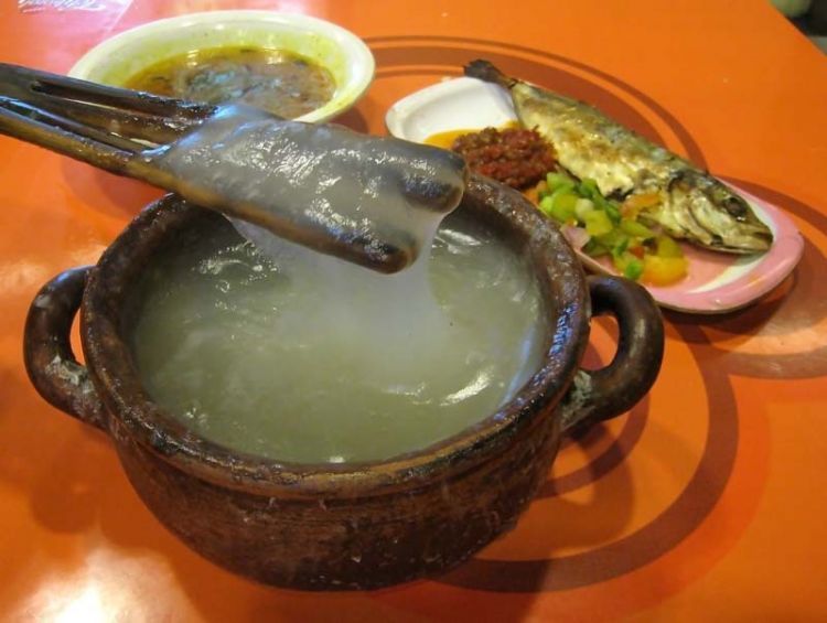 Papeda (sago congee), Kuah Kuning (yelow soup) and  Ikan Tude Bakar (grilled fish) with Dabu-dabu and Rica sambal. The Eastern Indonesian meal. Papeda, the staple food of Easter Indonesia have a glue-like consistency and texture. Waroeng Ikan Bakar, a restaruant specializing in Eastern Indonesian food (Manado, Maluku and Papuan cuisine). Atrium Senen Foodcourt, Jakarta, Indonesia.