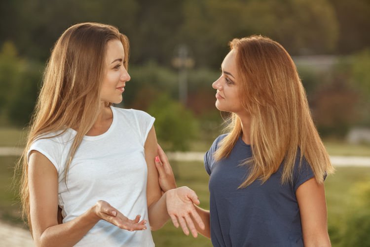 Two young girls having conversation in the park