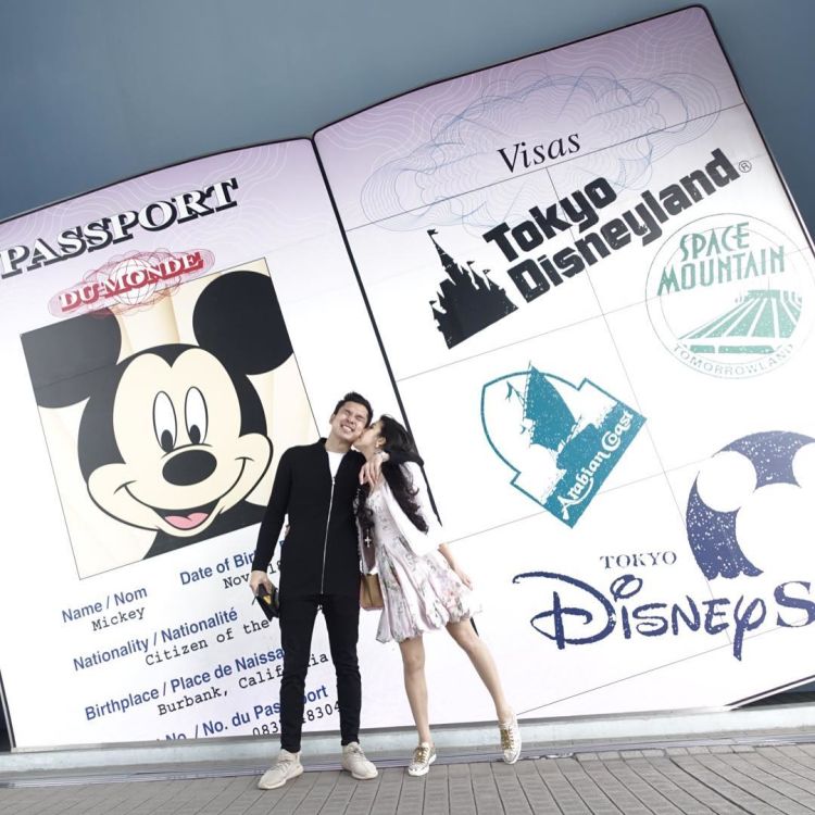 Berpose romantis berlatar Mickey Mouse.