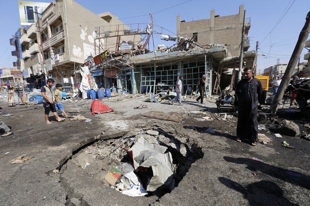 A man looks at the crater caused by an explosion after a car bomb attack in Baghdad's al-Ghadeer district, September 12, 2014. REUTERS/Thaier Al-Sudani (IRAQ - Tags: CIVIL UNREST POLITICS)