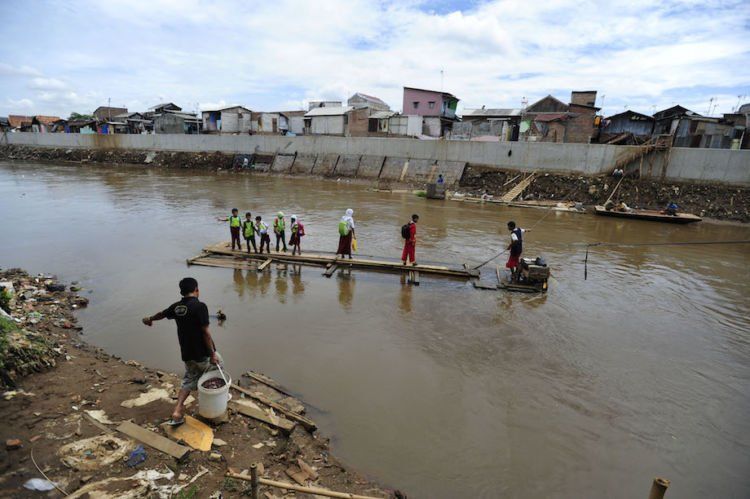 Sejumlah pelajar menyeberangi Sungai Ciliwung menggunakan eretan di kawasan Bukit Duri, Jakarta, Selasa (15/12). Pemprov DKI Jakarta menurunkan tim untuk mendata anak yang putus sekolah dan belum memiliki Kartu Jakarta Pintar (KJP) guna menekan angka putus sekolah yang mencapai 40 persen. ANTARA FOTO/Wahyu Putro A/kye/15