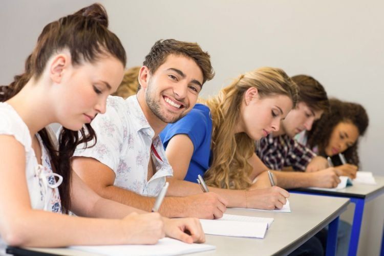 Students writing notes in classroom