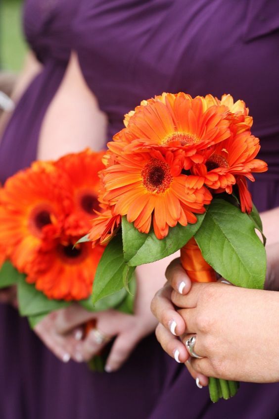 bridesmaid membawa buket daisy oranye