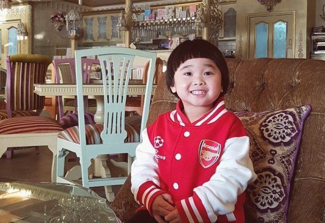 Grinning baby with two lower teeth showing