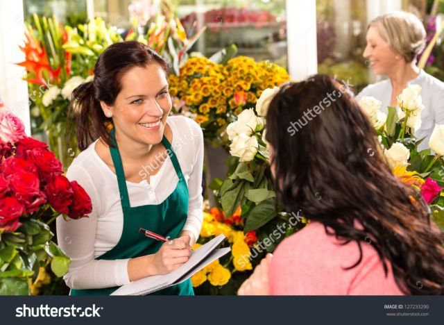 Happy florist writing flower shop