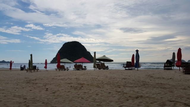 pantai pulau merah dan bukitnya di tengah laut