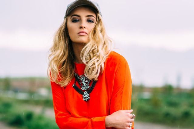 blonde-haired-woman-wearing-orange-crew-neck-long-sleeve