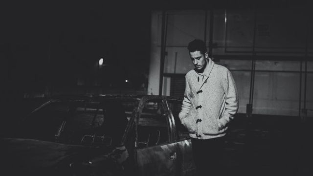 man-wearing-gray-jacket-near-black-car-during-night-time