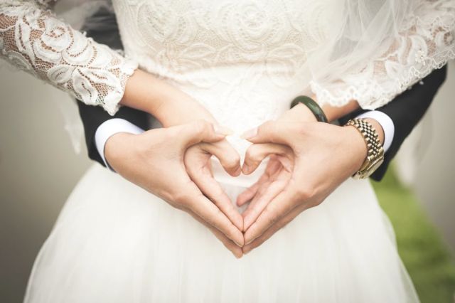 midsection-of-woman-making-heart-shape-with-hands