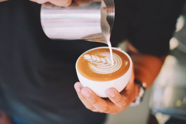 close-up-of-hand-holding-cappuccino