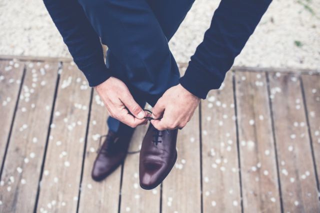 person-in-brown-leather-lace-shoes-tying-lace