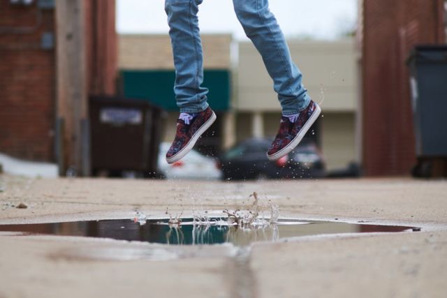 person-in-blue-denim-jeans-and-brown-slip-on-shoes-jumping-on-body-of-water