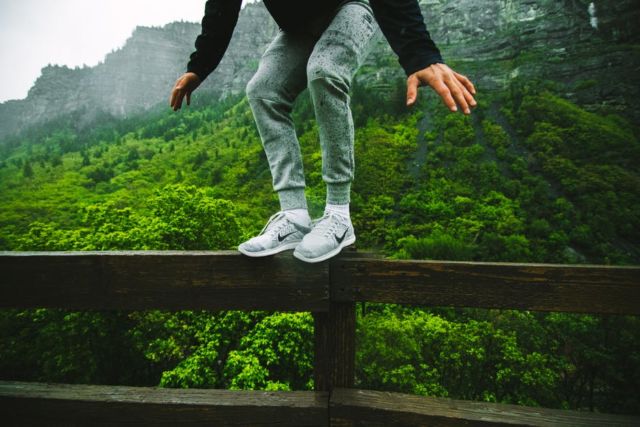 person-wearing-nike-white-shoes-on-black-wooden-frame