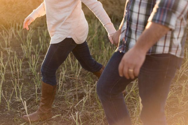 man-in-white-blue-and-black-plaid-dress-shirt-blue-jeans-holding-hand-with-girl-in-white-sweater-blue-jeans-and-brown-leather-boots