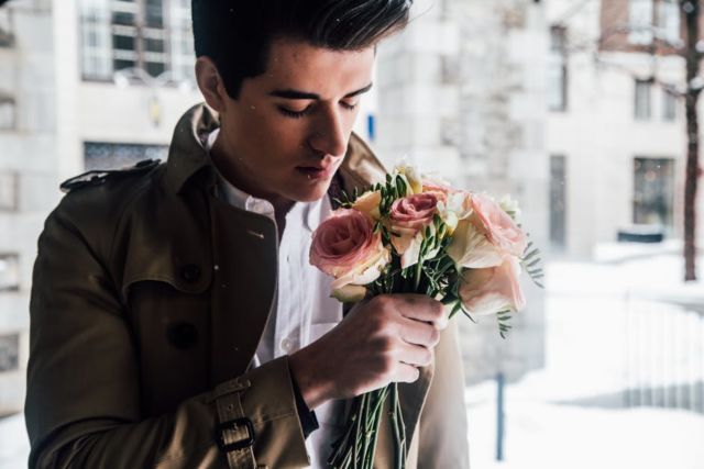 men-in-brown-jacket-holding-red-and-white-rose