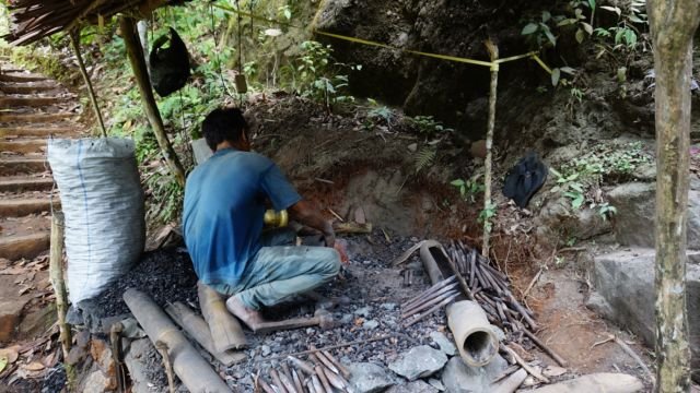 bapak ini sedang memahat batu tebing untuk pemakaman