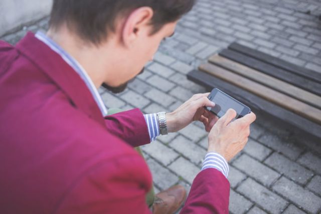 cobblestones-hands-man-mobile-phone