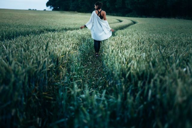 woman-walking-in-the-rice-plant-field-during-daytime