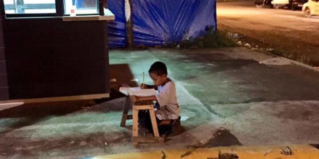 boy studying on street