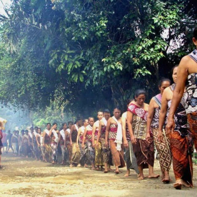 Berjalan kaki sambil membawa nasi ambeng.