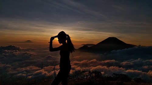 Wanita sedang memegang topi.