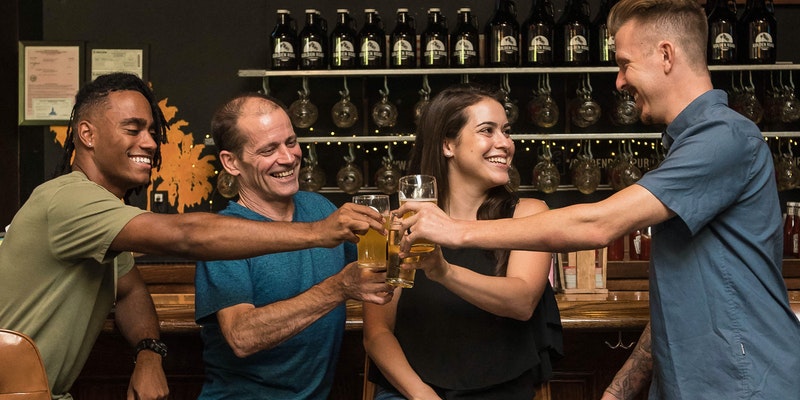 Four People Smilling Holding Glasses With Drinks 