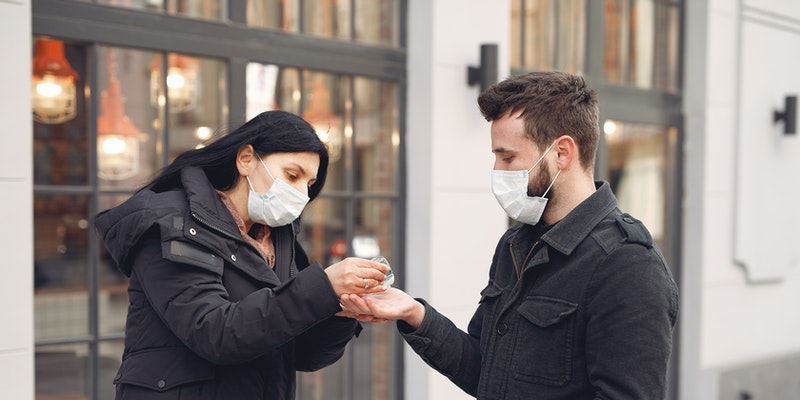 Women-Putting-Hand-Sanitizer-on-Man-s-Hand